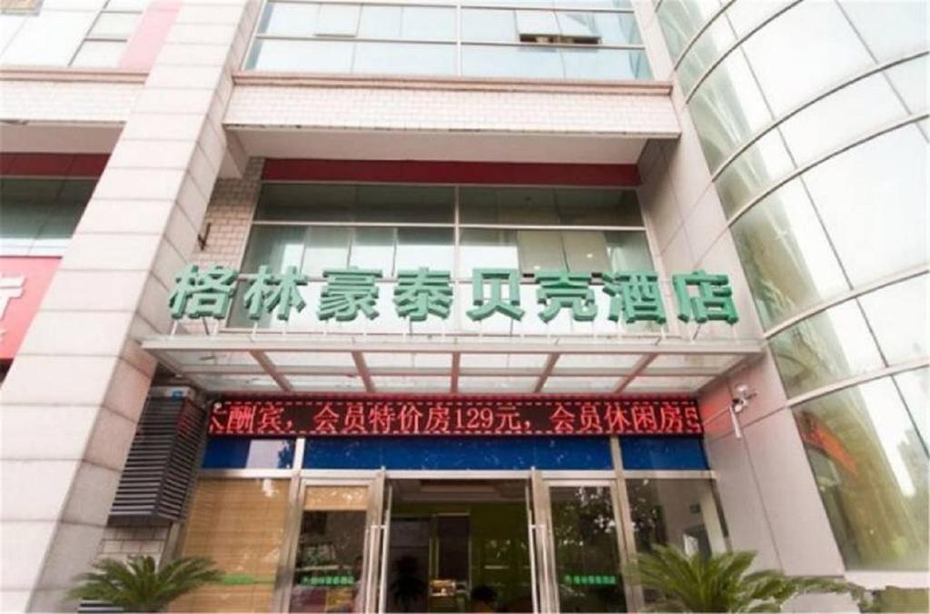 um edifício com uma placa na frente dele em GreenTree Jiangsu Suzhou Shilu Walk Street West Ganjiang Road Shell Hotel em Suzhou
