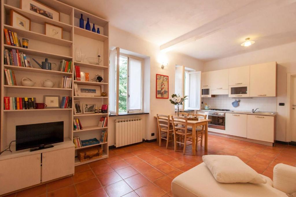 ジェノヴァにあるALTIDO Warm Flat for 4, Located in Quiet Areaのキッチン、リビングルーム(テーブル、椅子付)