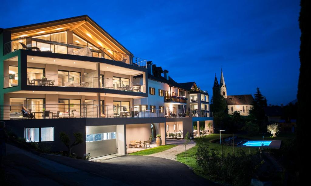 un gran edificio con balcones por la noche en Residence Prunarhof, en Caldaro