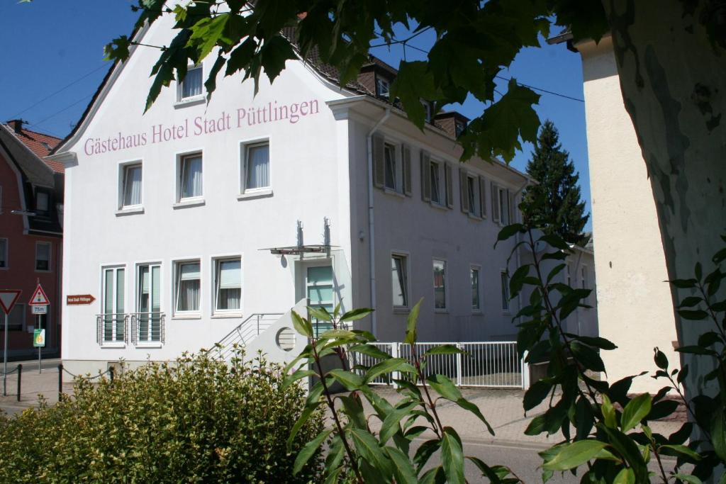Ein weißes Gebäude mit einem Schild drauf. in der Unterkunft Domizil Alte Post in Püttlingen