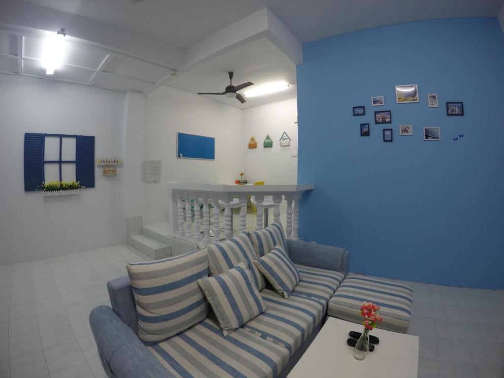 a living room with a couch and a blue wall at Little Blue House Kemaman Guesthouse in Cukai