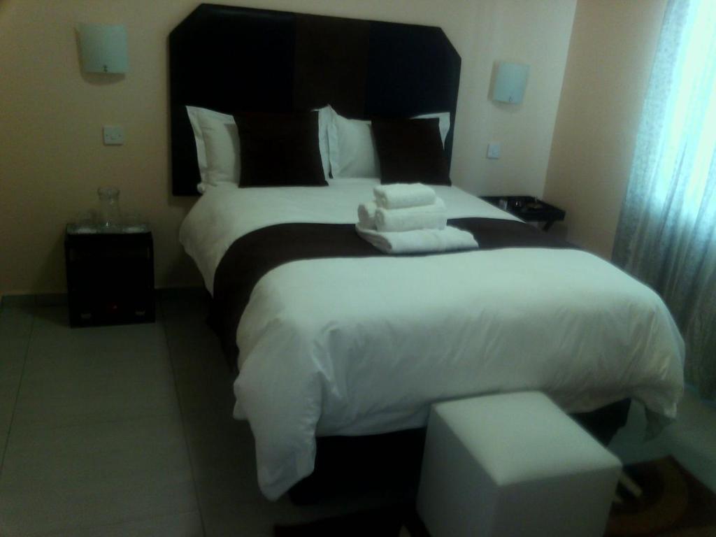 una habitación de hotel con una cama grande con toallas. en Fahms Self Catering, en Letlhakawe