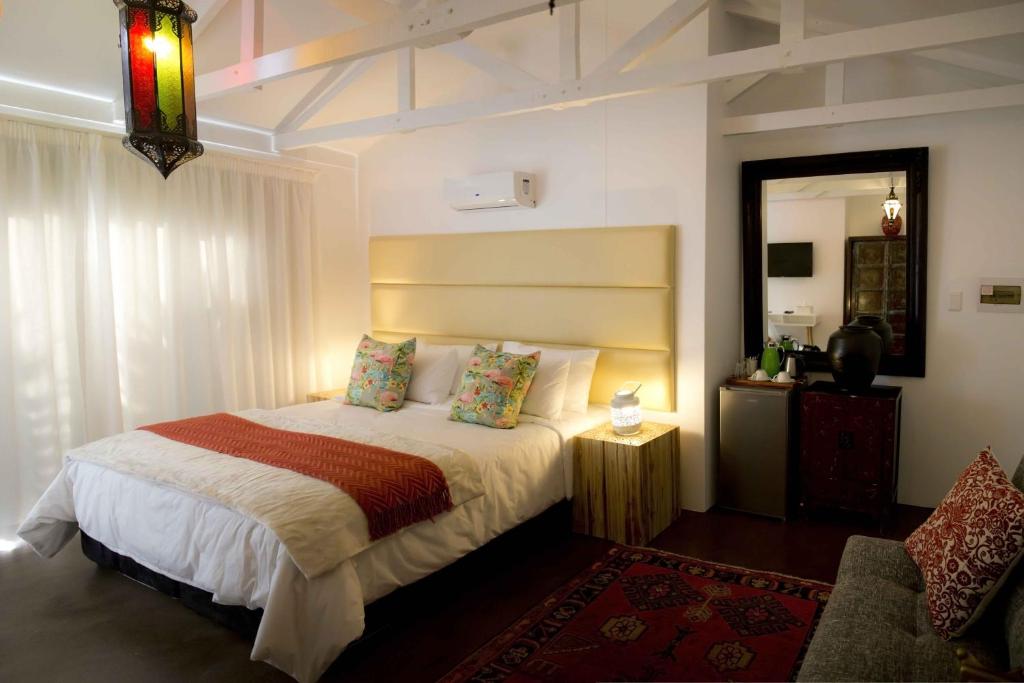 um quarto de hotel com uma cama e um espelho em The Rez Guesthouse em Walvis Bay
