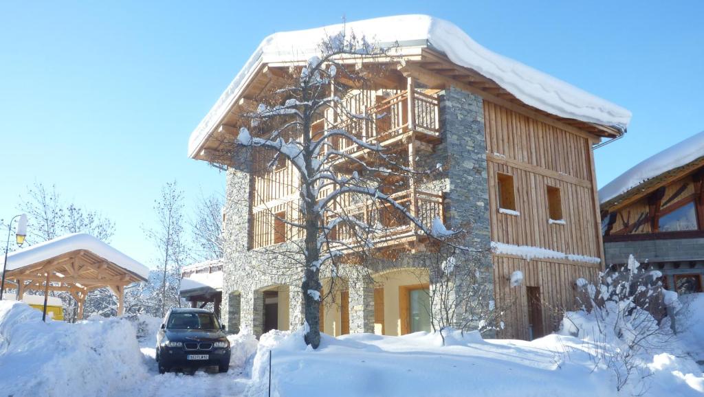 a snow covered house with a car parked in front of it at Chalet D' Edmond in Bourg-Saint-Maurice
