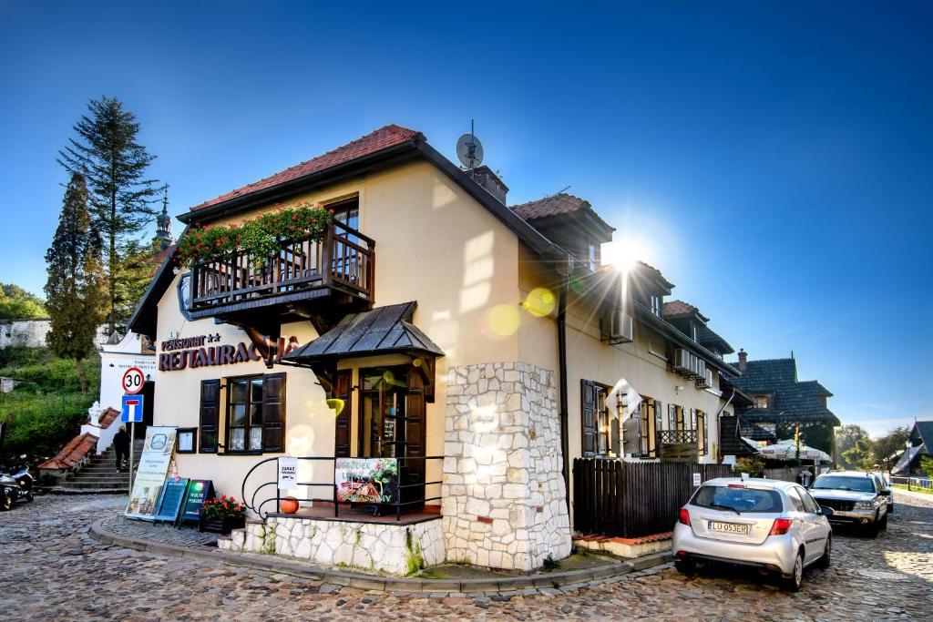 um edifício com um carro estacionado em frente em Pensjonat Pod Wietrzną Górą em Kazimierz Dolny