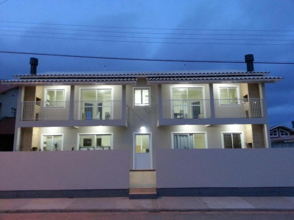 un gran edificio blanco con luces encendidas en Apartamento Sunset 101, en Palhoça