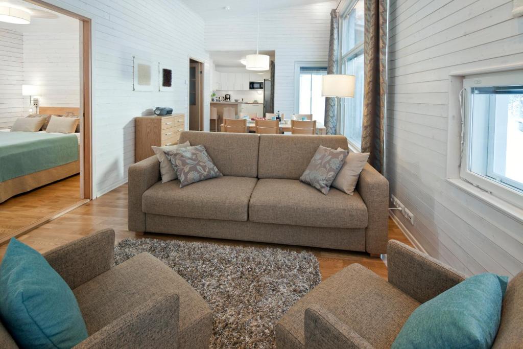 uma sala de estar com um sofá e um quarto em Holiday Club Kuusamon Tropiikki Superior Apartments em Kuusamo