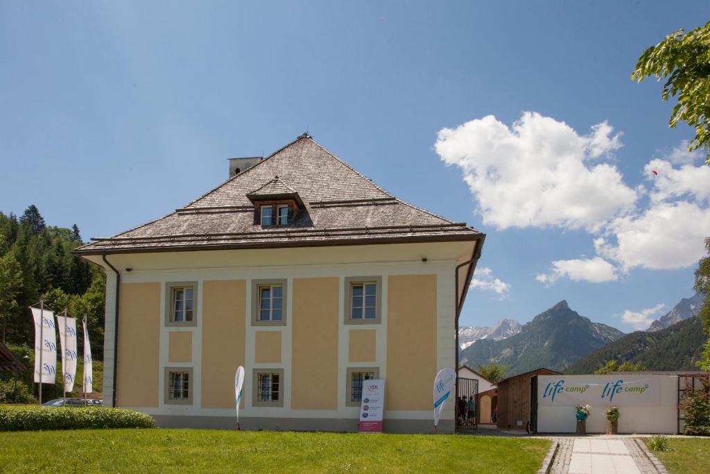 a building with a roof with mountains in the background at Life Camp in Hinterstoder