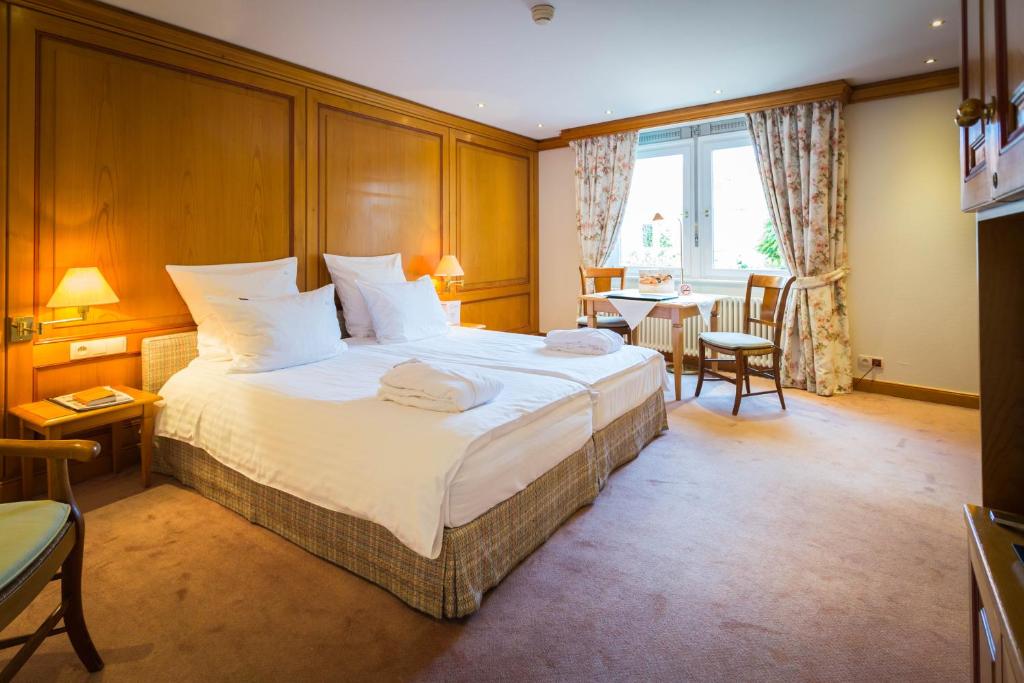 una habitación de hotel con una cama grande y una mesa en A La Cour d'Alsace by HappyCulture en Obernai