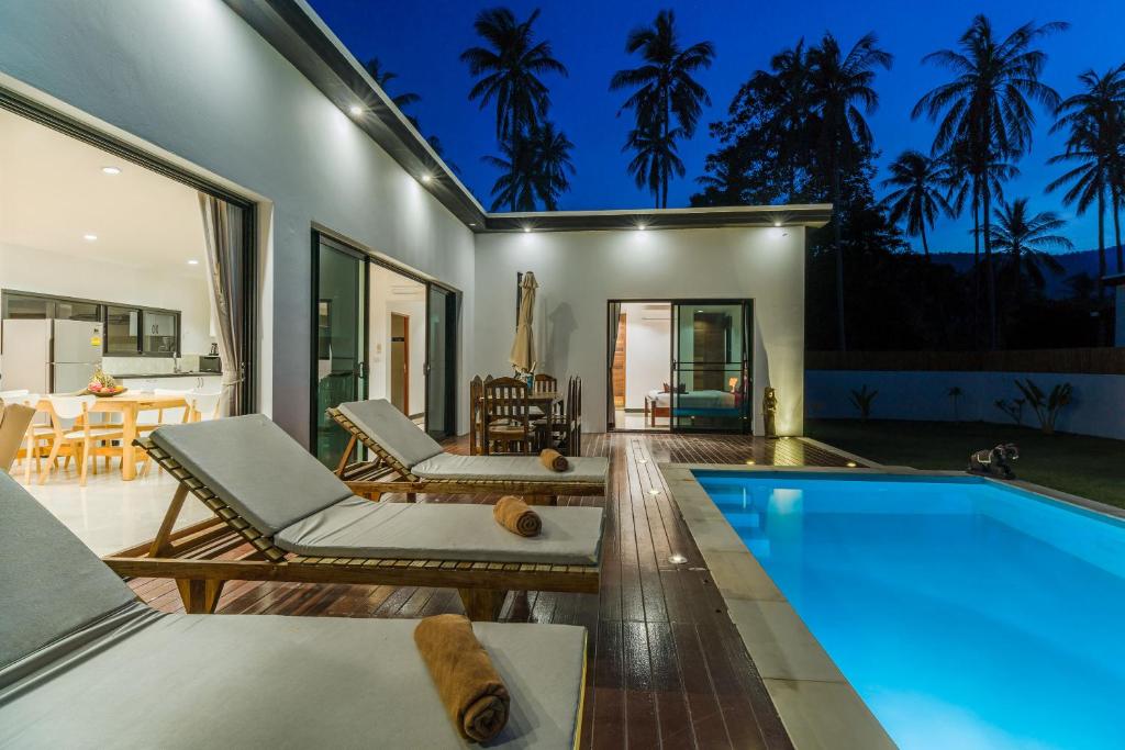 a home with a swimming pool and a patio at Villas Eden in Lamai