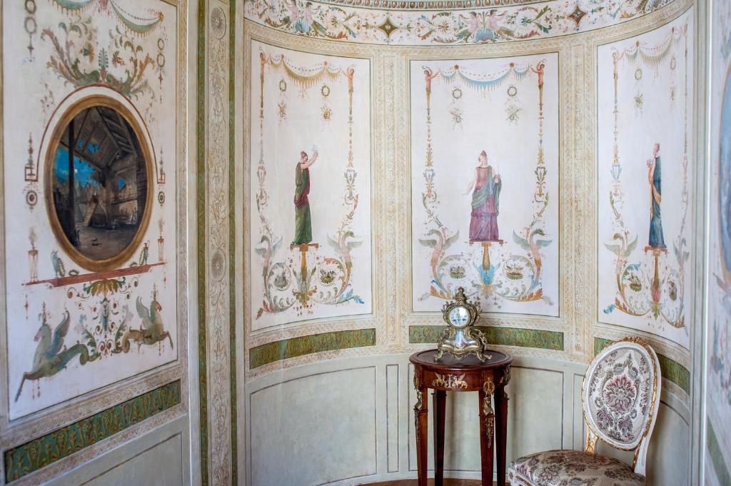 a room with a wall covered in wallpaper with paintings at Hotel Nani Mocenigo Palace in Venice