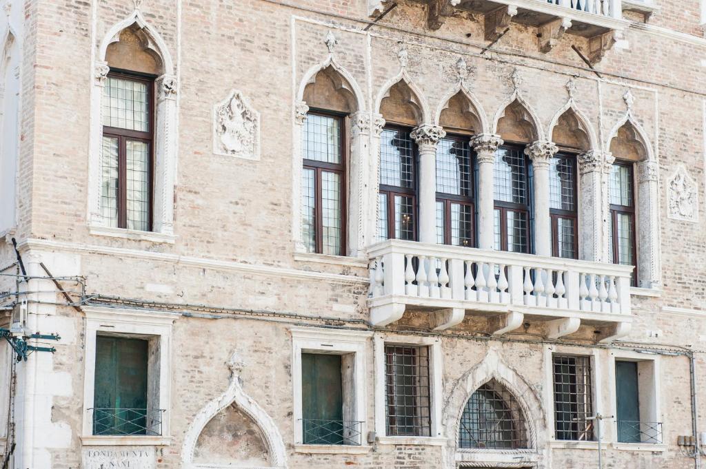 a building with a balcony on the side of it at Hotel Nani Mocenigo Palace in Venice