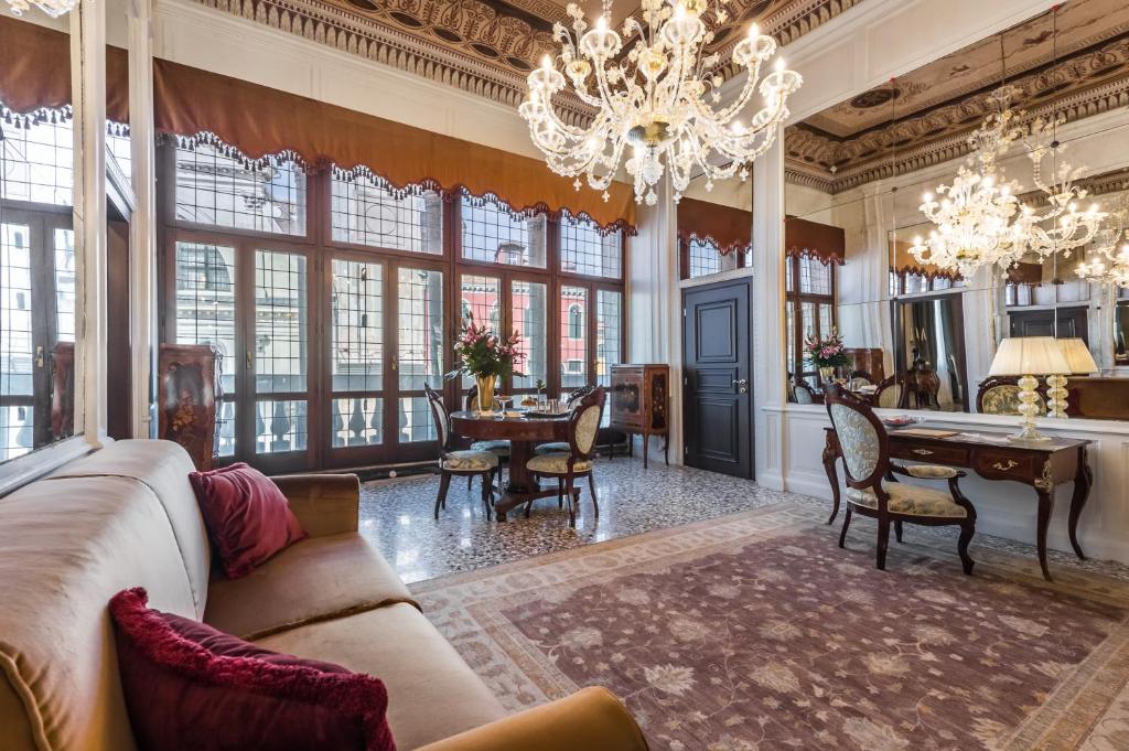 a large living room with a chandelier and a table at Hotel Nani Mocenigo Palace in Venice