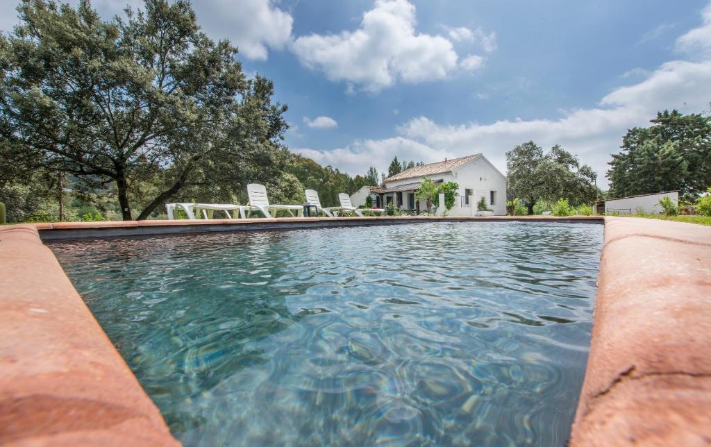 a swimming pool in front of a house at La Umbría de la Ribera in El Pedroso