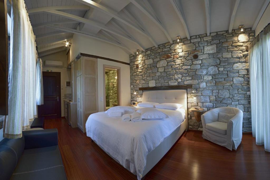 a bedroom with a large bed and a stone wall at Mple Feggari in Mouresi