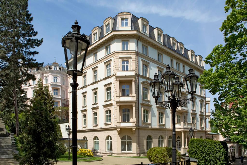 um grande edifício com duas luzes de rua em frente em Bristol Kralovska Vila em Karlovy Vary