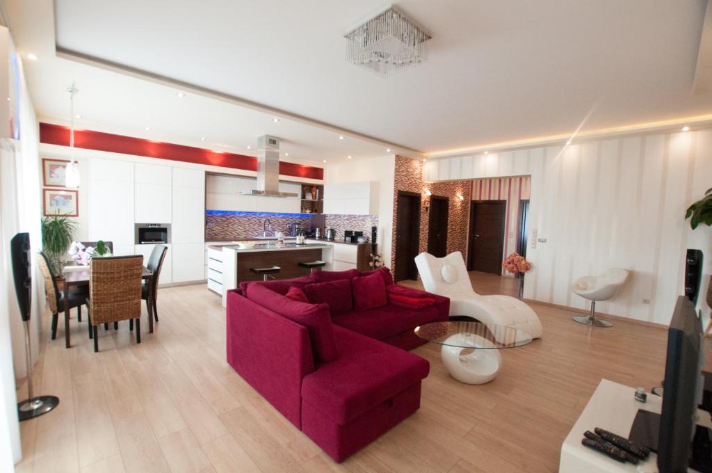 a living room with a red couch and a table at Prestige apartment in Komárno