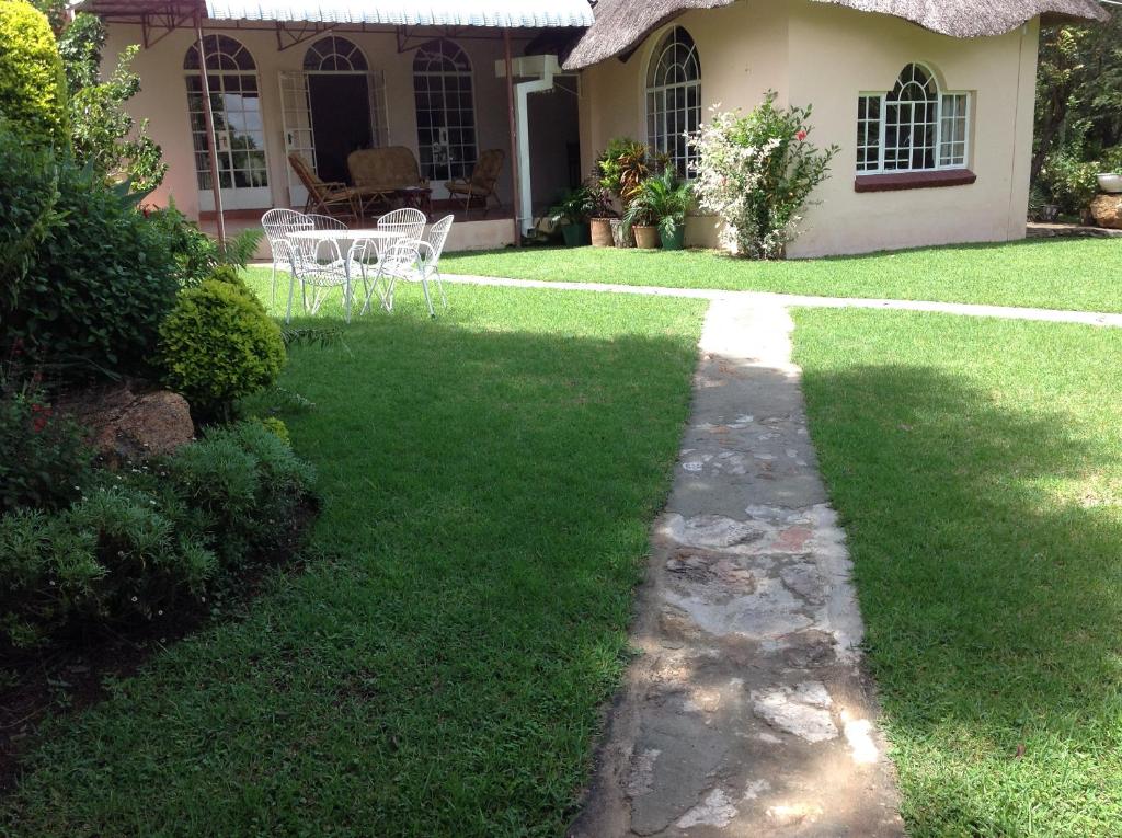 a garden with a pathway in front of a house at Lynns Guest House in Bulawayo
