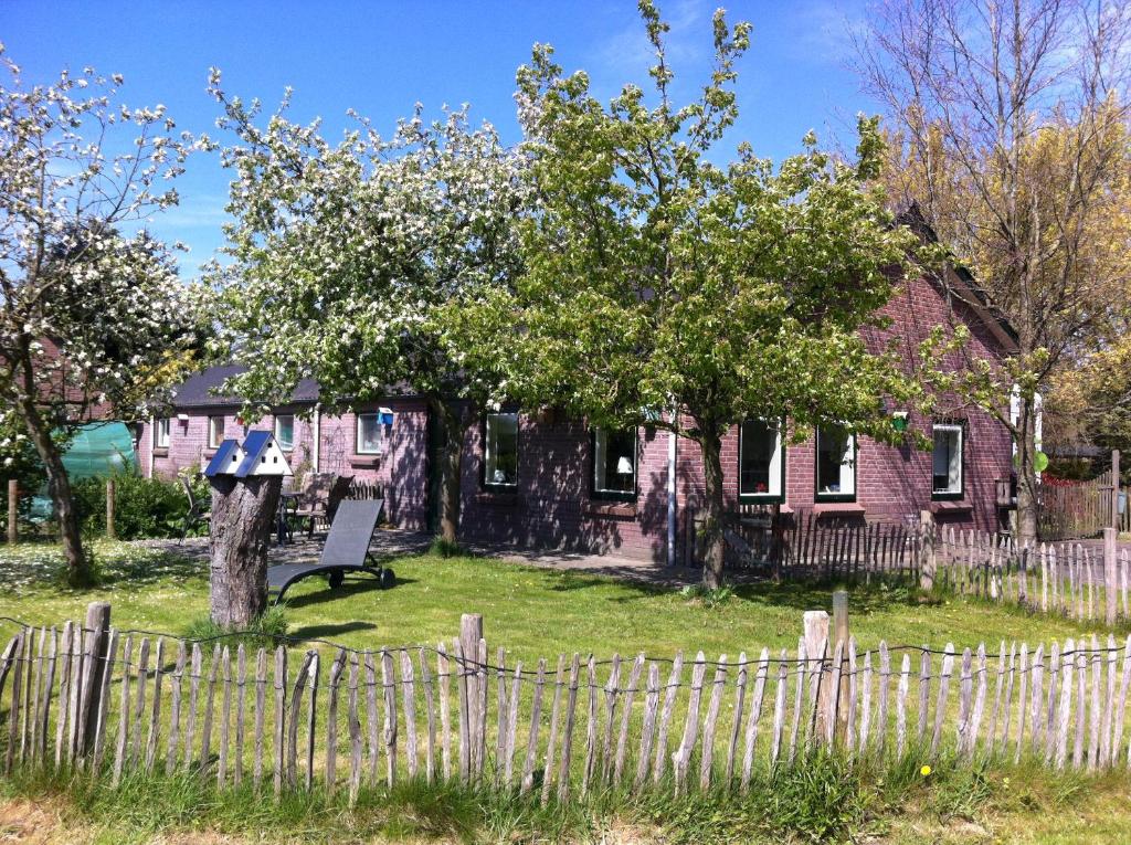 uma casa com um banco em frente a uma cerca em Elferink Hoeve em Woudenberg