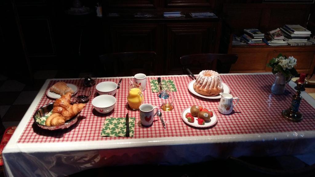 a table with a red and white table cloth with food on it at Chambre d&#39;Hôtes &quot;Au Vigneron&quot; in Triembach-au-Val