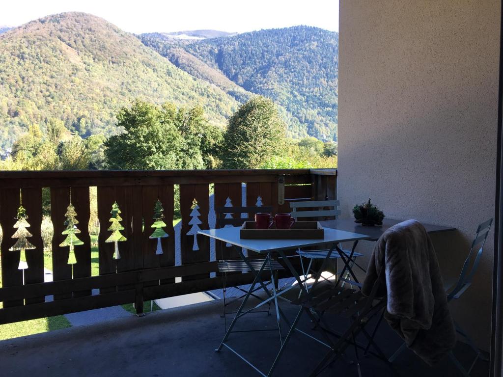 a balcony with a table and a view of mountains at Appartement familial vue montagne, Thermes, Ski et Randonnées à Luchon in Luchon
