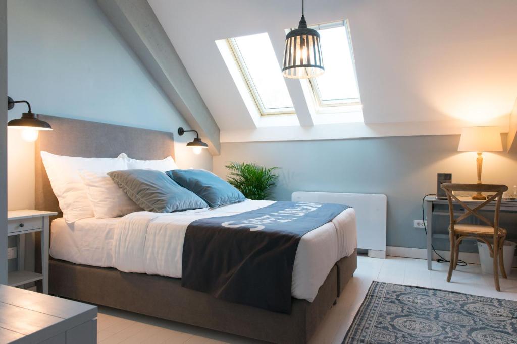 a bedroom with a large bed with two windows at Smokvica Dorćol B&B in Belgrade