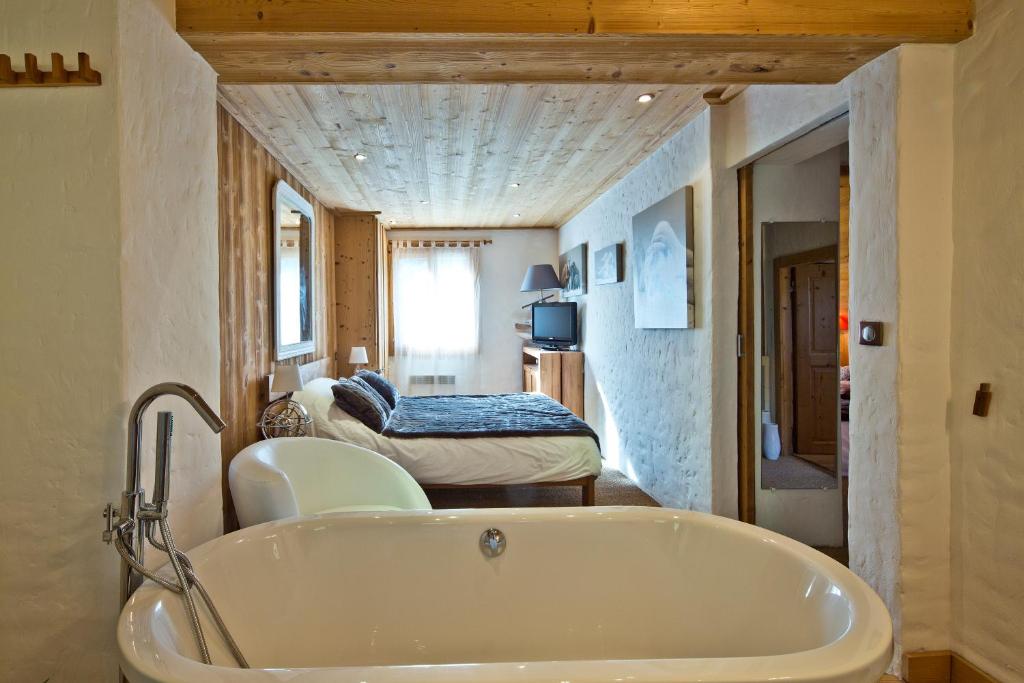 ムジェーヴにあるChalet la Brunetteのバスルーム(バスタブ付)、ベッドルーム1室が備わります。