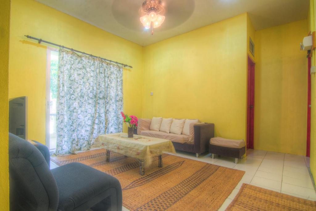 a living room with a couch and a table at Budget Umi Homestay Kuching in Kuching