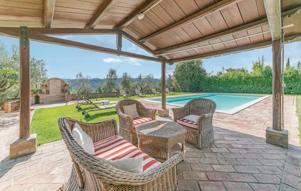 un patio esterno con sedie in vimini e una piscina di Agriturismo Wine Casale Villa Chiara a Torgiano