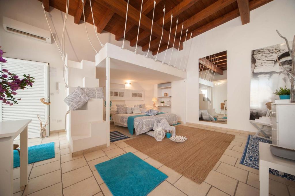 uma grande sala de estar com uma cama e tapetes azuis em Portadamare em Trani