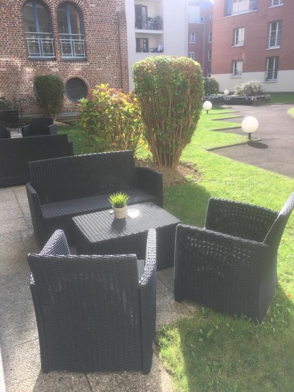 un patio con sillas negras, mesa, mesa y sillas en Place aux Oignons Vieux Lille 4 personnes, en Lille