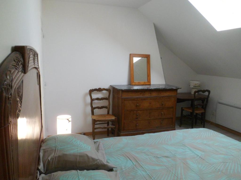 a bedroom with a bed and a dresser and a mirror at L'etape de St Hilaire La Gravelle in Saint-Hilaire-la-Gravelle