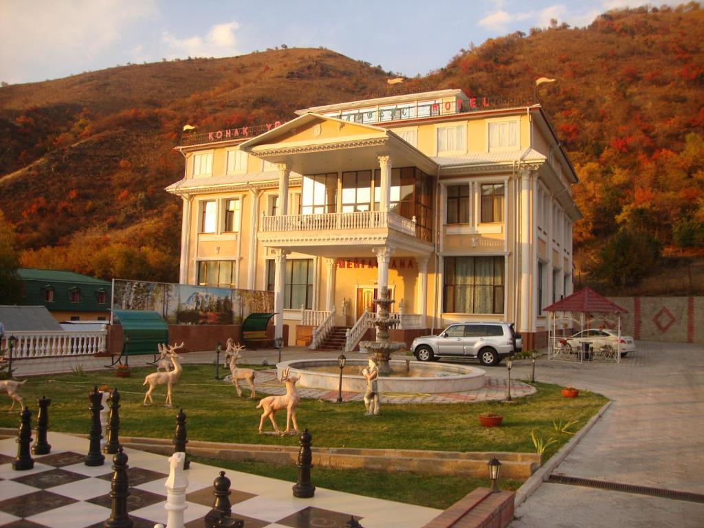 uma casa grande com estátuas de veados em frente em Эдельвейс em Almaty