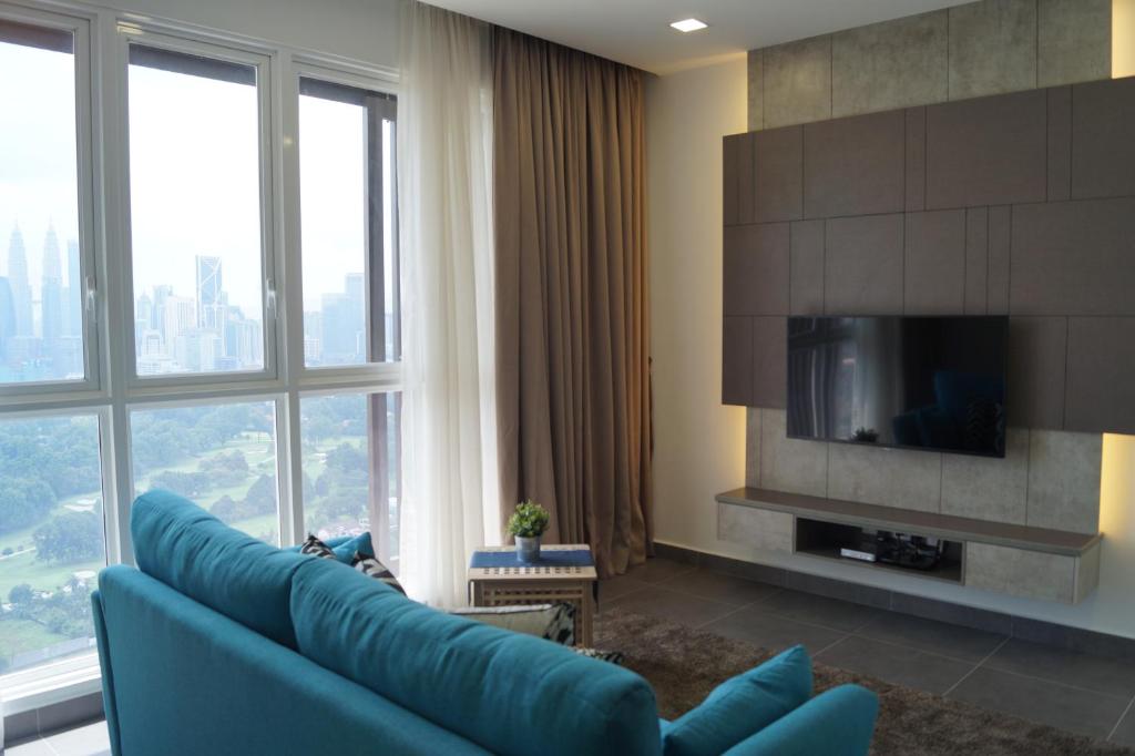 a living room with a blue couch and a tv at Sentrio Pandan Kuala Lumpur in Kuala Lumpur
