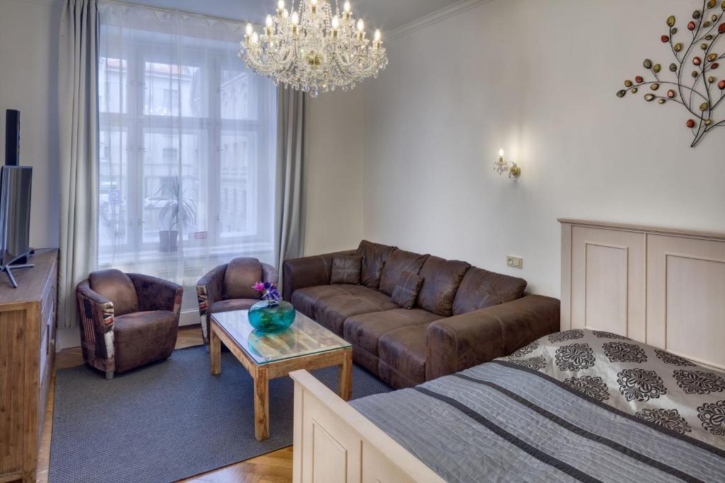 uma sala de estar com uma cama, um sofá e uma mesa em Dušní 13 - Old Town Apartment em Praga