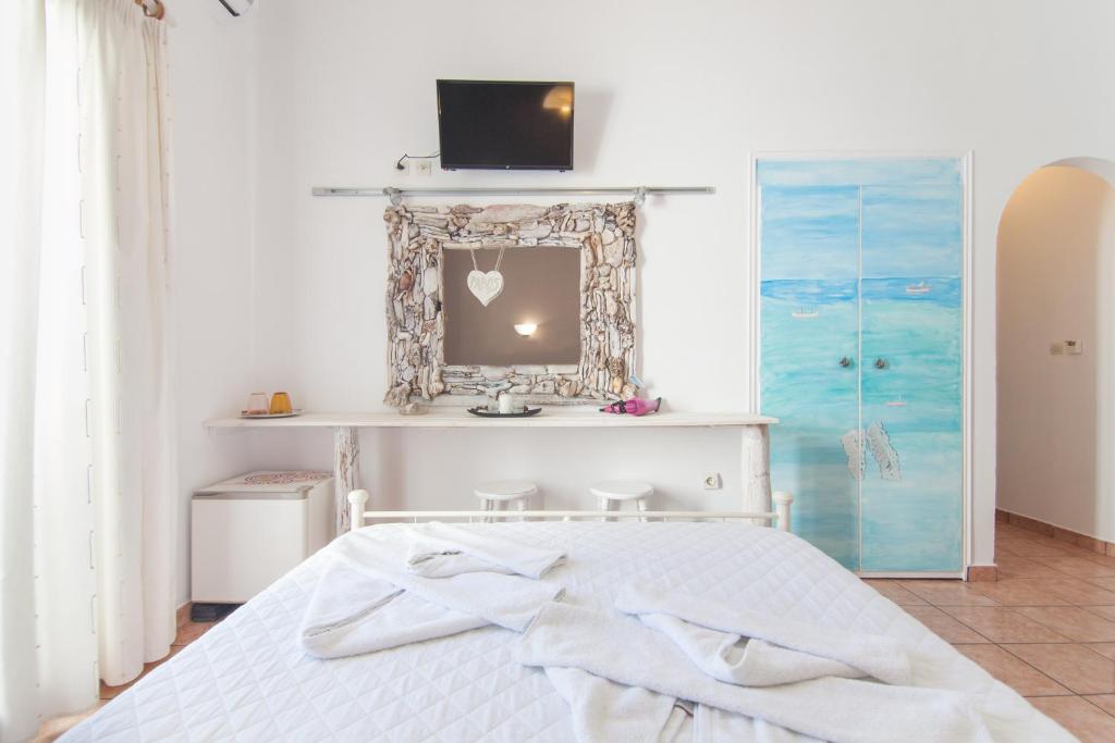 納烏薩的住宿－瑪達琪酒店，卧室配有一张床铺,墙上配有电视