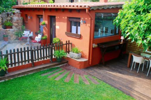 a small house with a piano on a deck at Casa Rosa Garden House in Santa Cristina d'Aro