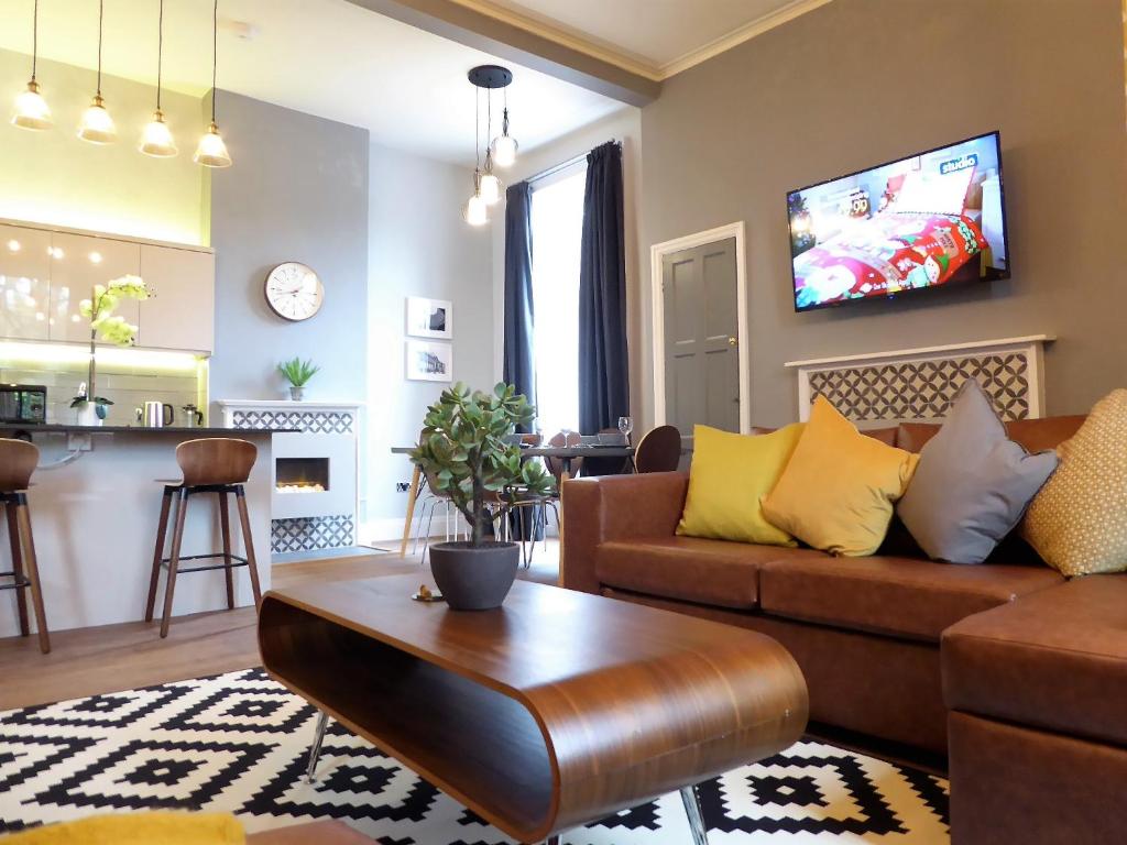 a living room with a couch and a table at The Broderick at Claremont Apartments in Leeds