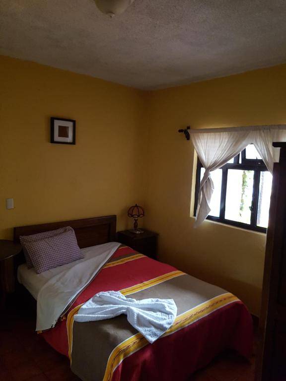 Postel nebo postele na pokoji v ubytování Hotel Nuevo Cupatitzio
