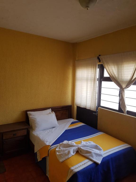 Postel nebo postele na pokoji v ubytování Hotel Nuevo Cupatitzio