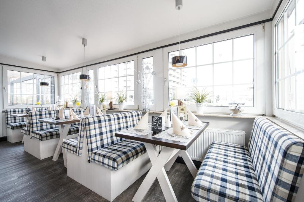 un restaurante con sofás, mesas y ventanas en Hotel Gasthof Zur Post en Cuxhaven