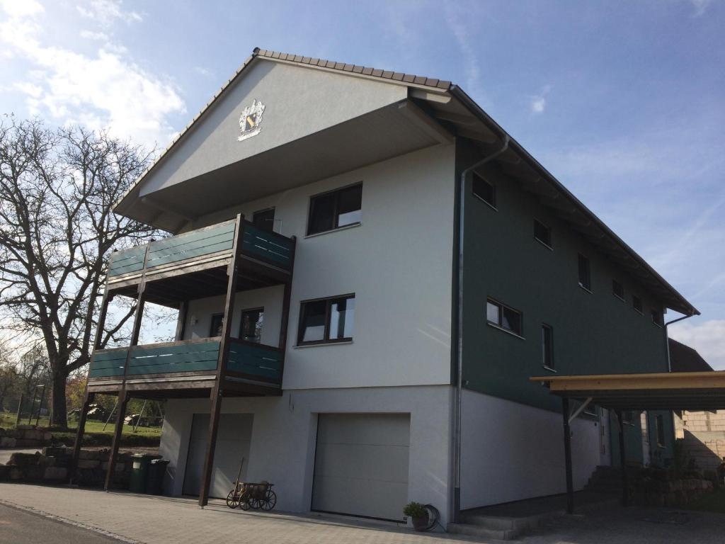 a green and white building with a roof at Messewohnung Rehdorf in Oberasbach