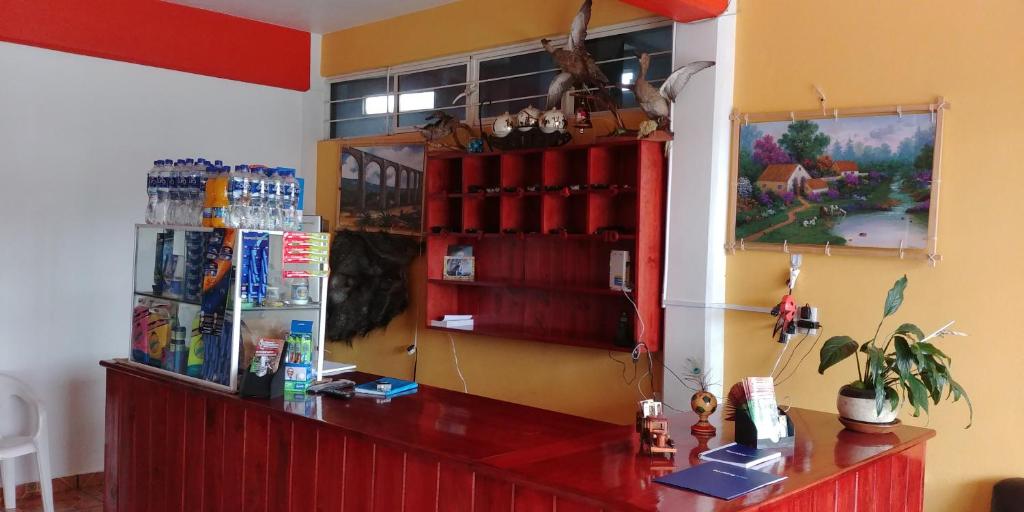 un bar con barra roja en una habitación en Hotel Don Fer en Chignahuapan