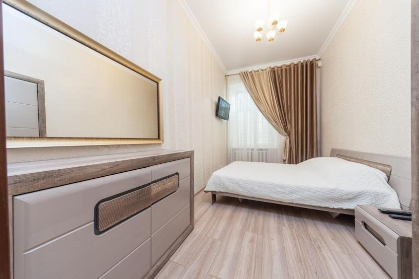 a bedroom with a bed and a large mirror at center, Apartment on Deribasovskaya 10 in Odesa