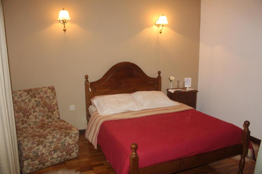 1 dormitorio pequeño con 1 cama y 1 silla en Bem Sonhar en Terras de Bouro