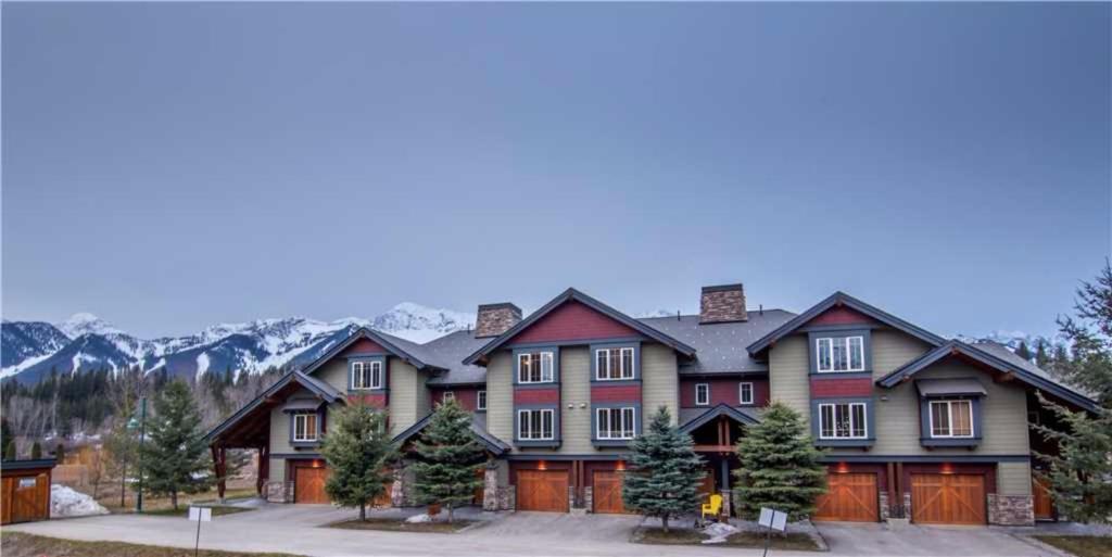 ein großes Haus mit Bergen im Hintergrund in der Unterkunft Pinnacle Ridge Chalets by Fernie Lodging Co in Fernie