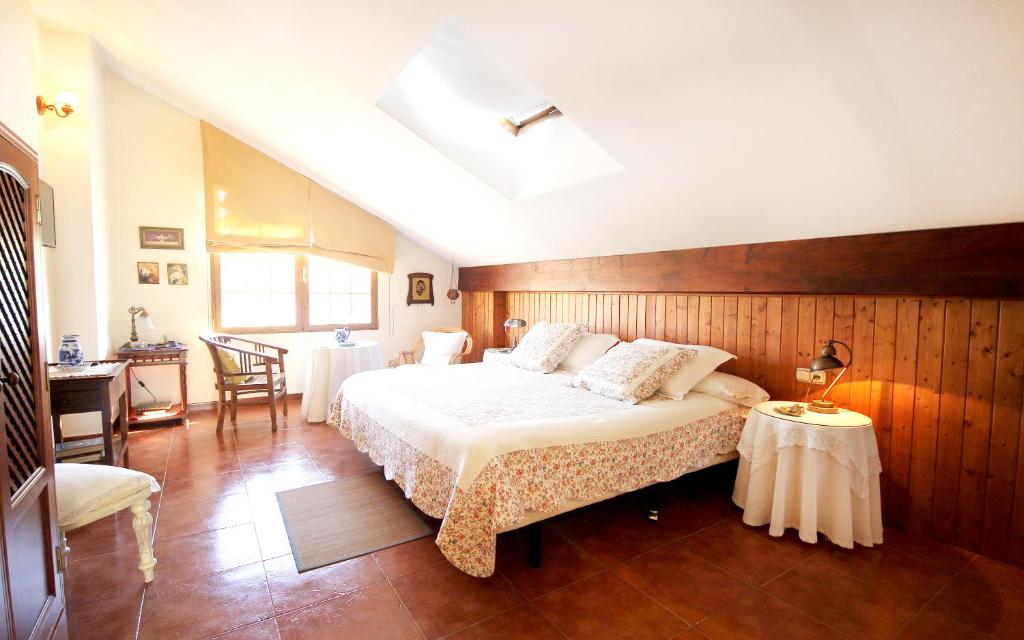 1 dormitorio con 1 cama grande y 1 mesa en Hotel Boutique Alicia Carolina en Monachil