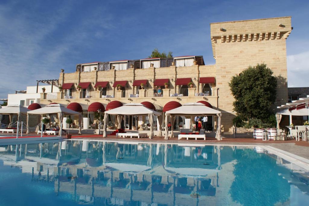 un hotel con piscina di fronte a un edificio di Messapia Hotel Resort a Leuca