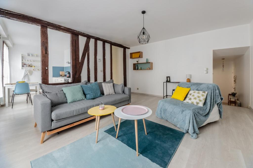 a living room with a couch and a table at Le République in Châlons-en-Champagne