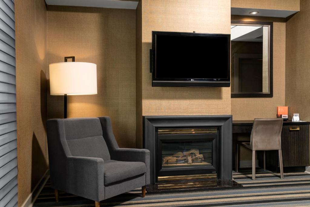 a living room with a fireplace and a flat screen tv at Hotel Arts Kensington in Calgary
